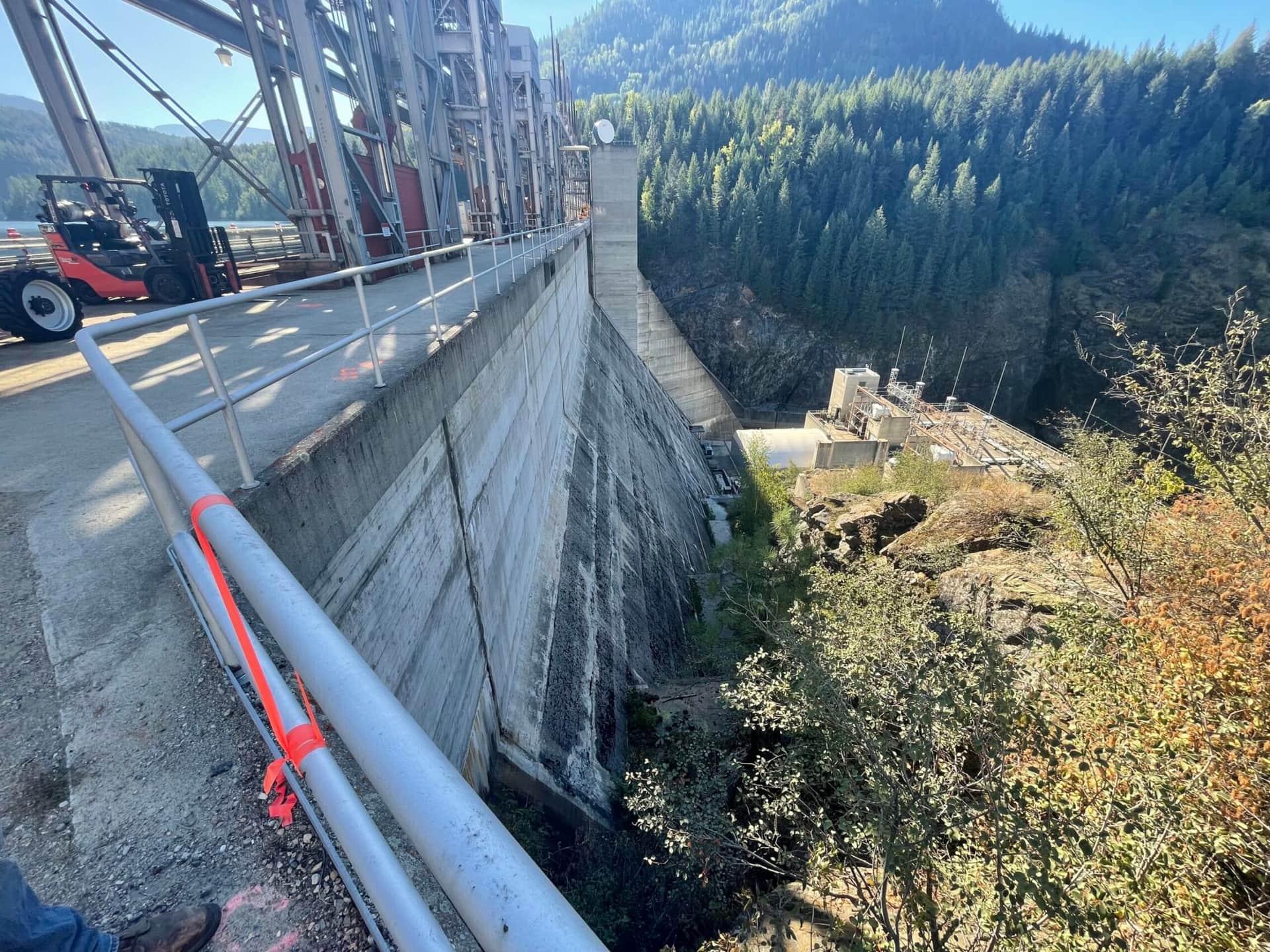 a concrete wall with metal structures and trees