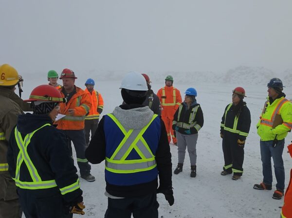 a group of people in safety gear standing in snow