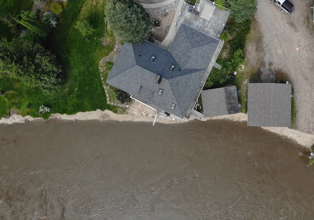 Portfolio: government 2 Aerial view of flooded river near a home e1777727318231
